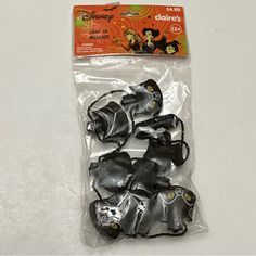 some black and silver items in plastic bags on a white table with an orange tag