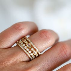 a woman's hand with a gold and diamond ring