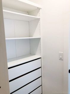 an empty closet with white shelves and drawers