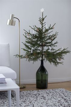 a small christmas tree in a green vase