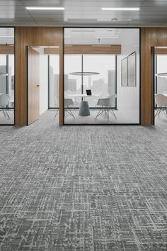 an empty conference room with glass walls and chairs