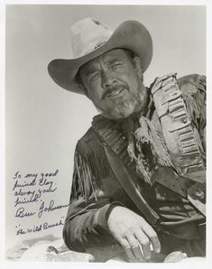 an old black and white photo of a man wearing a cowboy hat with his hand on his hip