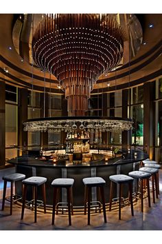 a bar with several stools and a chandelier hanging from the ceiling