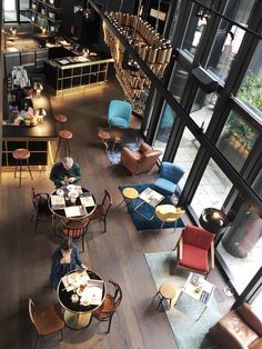 an overhead view of people sitting at tables in a large room with lots of windows