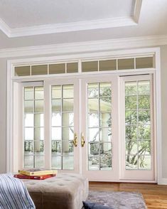 a living room filled with furniture and lots of glass doors leading to an outside patio