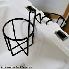 two black wire baskets sitting on top of a white sink