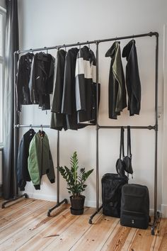 a room with some clothes hanging on the wall and a bag sitting next to it