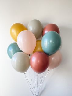 a bunch of balloons that are in the shape of a heart on a white wall