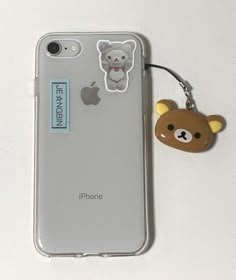 an iphone case with a bear sticker on the back and a keychain attached to it