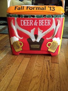 an old fashioned beer cooler with deer and beer mugs on the front, sitting on a wooden floor