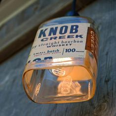 a light hanging from the side of a wooden wall next to a sign that says knob creek