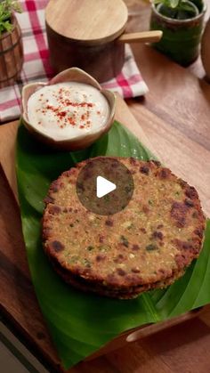 two food items sitting on top of a green leaf next to a bowl and spoon