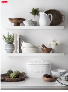 white shelves with bowls, plates and plants on them are featured in this article by interior stylist