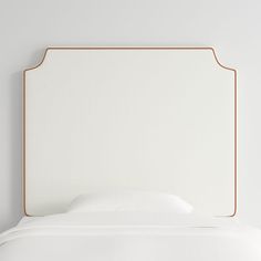 a white bed with an orange trim around the headboard