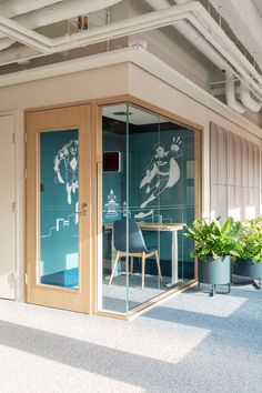 an office with glass walls and planters on the floor