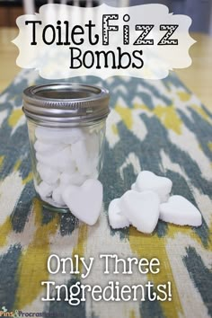 a jar filled with white marshmallows sitting on top of a tablecloth