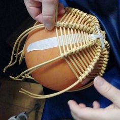 a person holding a basketball in their hand and string wrapped around the ball with tape on it