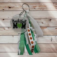 a keychain hanging from the side of a wooden wall that says basketball mom