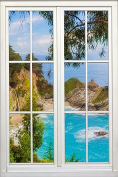 an open window showing the ocean and beach from it's windowsill, with trees in the foreground