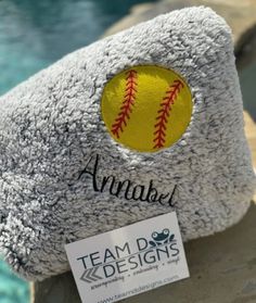 a stuffed animal with a baseball on it's back sitting next to a pool