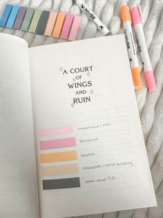 a book that has some writing on it with markers next to it and two crayons