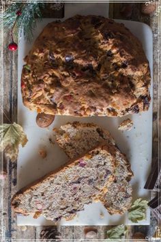 a loaf of fruit bread on a cutting board with slices cut out and ready to be eaten