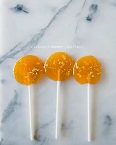 three lollipops sitting on top of a marble counter