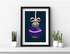 a purple christmas ornament with a bow hanging from it's side on a shelf next to potted plants