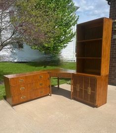 an office desk and bookcase sitting in the driveway