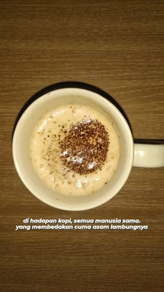 a white bowl filled with food on top of a wooden table next to a cup of coffee