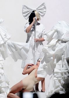 two women in white dresses are performing on stage