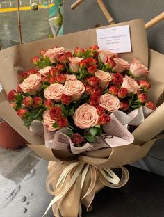 a bouquet of roses wrapped in brown paper