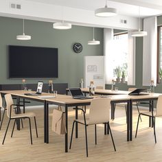 a white table and chairs in a room with a large screen on the wall behind it