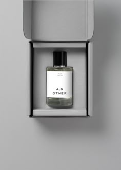 an other bottle in a grey box on a gray wall next to a black and white object