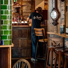 a man sitting at a bar in front of a clock