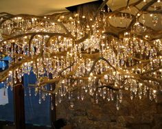 a chandelier hanging from the ceiling in a room with stone walls and windows