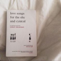 the book love songs for the shy and cystical by robert sherman is laying on a bed