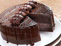 a chocolate cake on a plate with one slice cut out and ready to be eaten