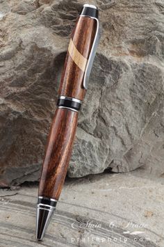 a wooden pen sitting on top of a rock