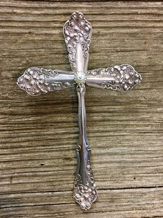 an ornate silver cross on a wooden surface