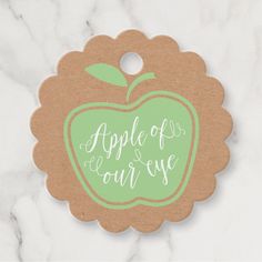 an apple ornament with the words apple of our eye written in cursive writing