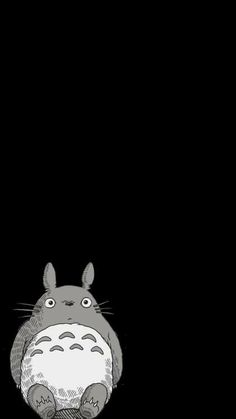 a black and white image of a totoro sitting in the dark