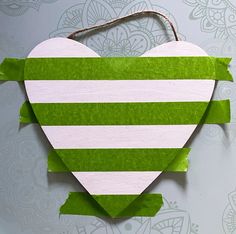 a green and white striped heart hanging on a wall