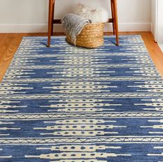 a blue and white area rug with a basket on the floor in front of it