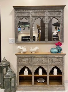 an ornate wooden cabinet with mirrors on the wall