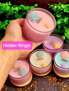 a hand is holding several small containers with different designs on them and the words hidden rings above it