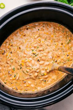 a slow cooker filled with beans and corn