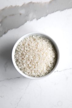 a white bowl filled with rice on top of a table