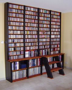 two bookshelves filled with many different types of dvd's