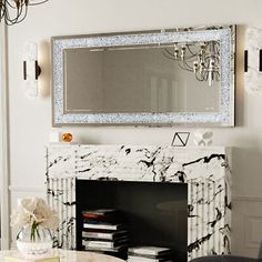 a living room filled with furniture and a mirror on the wall above a fire place